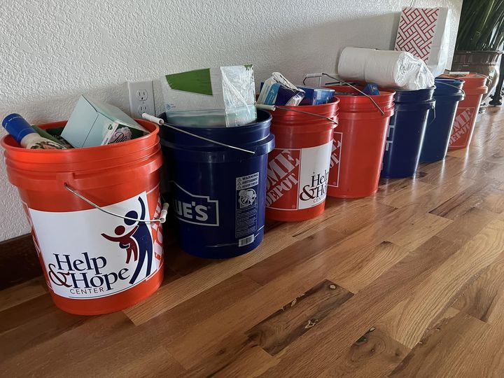 a line of buckets willed with household goods that are going to be given to a local non-profit Help and Hope